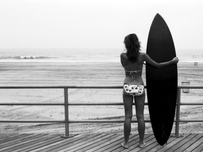 Model with Black Surfboard Standing on Boardwalk and Watching Wave on Beach Poster