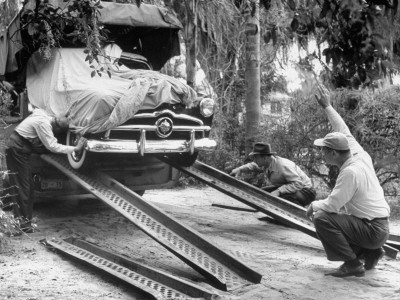 Unloading the New Ford Car, Swathed in Canvas, to Make Advertising Pictures of the New Model