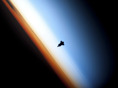 Silhouette of Space Shuttle Endeavour over Earth's Colorful Horizon