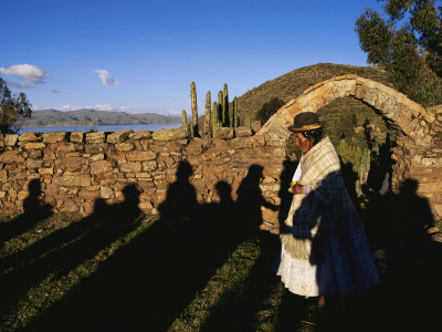 Buy Shadows of Festival Revelers Fall across a Woman and a Stone Wall at AllPosters.com