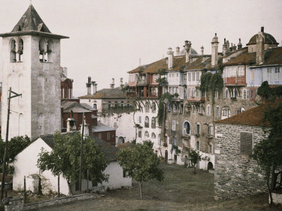 Buy A White Bell Tower Stands Bright Against the Red Katholikon at AllPosters.com