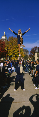 Woman Standing One Leg on a Man Hand and Performing a Stunt, University of Notre Dame Poster