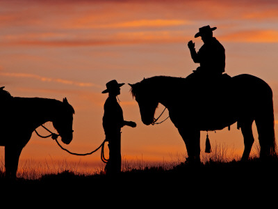 Cowboy and Cowgirl Silhouetted on a Ridge in the Big Horn Mountains, Wyoming, USA