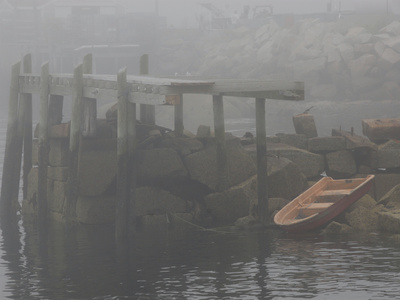 Rowboat in the Rocks and a Pier in Early Morning Fog