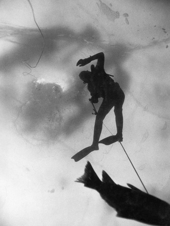 An Ice Fisherman Drags a Carp Upward Toward a Hole in the Lake