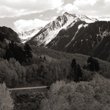 High angle view of road winding up the side of a hill with mountains in the distance