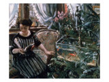 A Woman Reading Near a Goldfish Tank