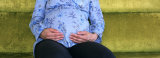 Mid Section View of a Pregnant Woman Touching Her Abdomen, USA