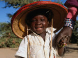 Buy Young Smiling Boy Wearing a Typical Mali Hat and Holding His Mother's Hand, Djenne, Mopti, Mali at AllPosters.com