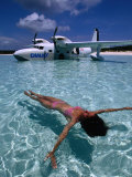 Female Floating in Crystal Waters in Front of Seaplane, Bahamas