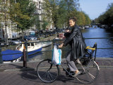 A Dutch Woman with Her Baby Cycling Along Kaizersgracht Canal, Amsterdam, the Netherlands (Holland)