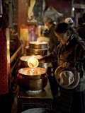 Woman Adding the Melting Yak Butter from Her Lamp to Those of the Temple, Bharkor, Tibet