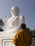 Monk Standing in Front of the Great Seated Figure of the Buddha, Mihintale, Sri Lanka, Asia