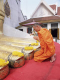 Buddhist Monk Kneeling and Praying at the Feet of a Standing Buddha, Thailand