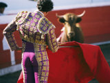 Bullfighter Holds his Red Cape Before a Bull