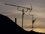 Silhouetted Television Antennas Reach into the Suburban Sky at Sunset