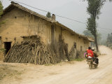 Two People on Motorcycle Ride on Dirt Road Past Rural Chinese Home, Hubei, China