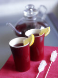 Two Beakers of Fruit Tea with Lemon Wedges, Sugar Sticks