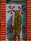 Woman in a Beautifully Patterned Long Headshawl and Pants Framed by a Painted Doorway