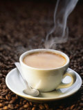A Steaming Cup of Coffee on Coffee Beans