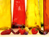 Various Types of Peppers in Front of Red & Yellow Bottles