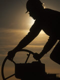 Silhouette of Oil and Gas Worker Turning Valve