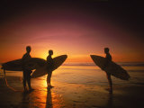 Buy Three Surfers Hold Surfboards on Beach at Sunset at AllPosters.com