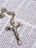 Silver Crucifix Lying on Open Bible