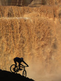 Buy Mountain Biker Pedals Past Rushing Winter Snow Melt at Grand Falls at AllPosters.com