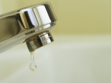 Water Dripping from a Leaking Bathroom Faucet, Wasting Water