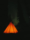 The Glow from a Campfire Makes a Shadow on a Tepee