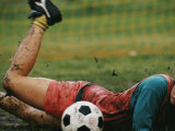 Buy A Soccer Player Lands in the Mud in an Attempt to Field the Ball at AllPosters.com