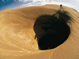 Buy A Mountain Biker Cycles Around a Spectacular Crater in the Desert at AllPosters.com
