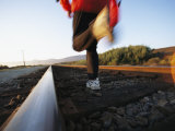 Buy An Athlete Runs on Railroad Tracks Toward the Mountains at AllPosters.com