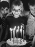 Little Girl Blowing Out Her Candles on Her Birthday Cake