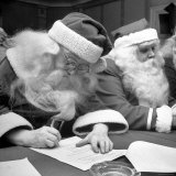 Santa Clauses Take a Written Examination For Diploma After Listening to Lectures