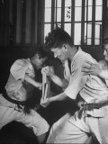 Japanese Karate Student Breaking Boards with Punch