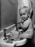Adorable Baby Brushing Teeth While Sitting in Sink