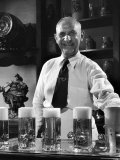 Bartender Smiling as He Serves Large Glasses of Beer
