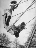 Children Riding the Swings at the Fair