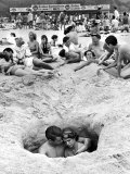 Buy Couple Cuddling While Sitting in a Hole as Others Enjoy the Beach on the 4th of July at AllPosters.com