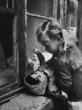 3 Year Old Child Playing with Doll on Window Sill of Apartment