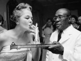 Buy Woman Lighting a Cigarette from a Candle Held by a Waiter at the Piedmont Ball at AllPosters.com