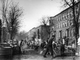 Many Men Hard at Work Paving a Street