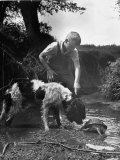 Young Farm Boy Watching His Dog Sniff a Large Turtle at the Pond