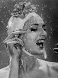 Woman Wearing Flowered Bathing Cap and Applying Mascara as Water Showers Around Her