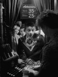 Teenage Boy Peering Into Window of Ticket Booth at a Movie Theater