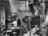 Sand Being Sifted by Worker Into Molds in Factory