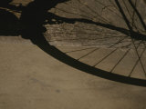 A Bicycle Wheel Casts a Shadow on a Wall and Sidewalk in Siena