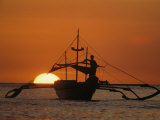 Buy A Man and an Outrigger Silhouetted against a Brilliant Orange Sky at AllPosters.com